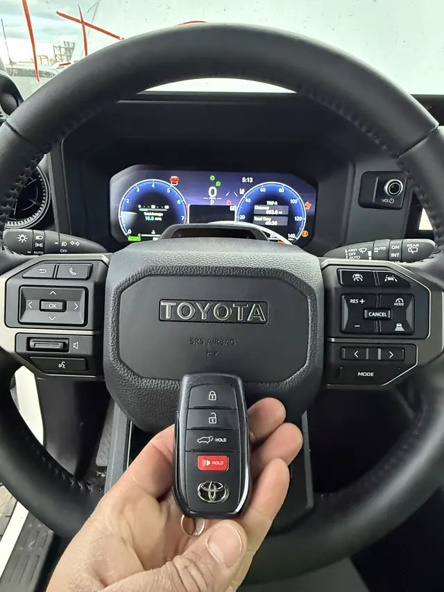 Toyota smart key held in front of a Toyota steering wheel